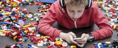 Ребенок в наушниках со смартфоном в руках